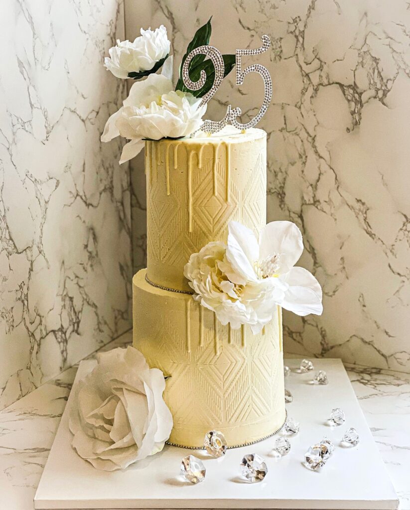 Single tier ivory geometric textured buttercream 25th birthday cake with decorative florals, metallic drip accent, and rhinestone number topper created by Luxe Layers Cakery in Miami Florida.