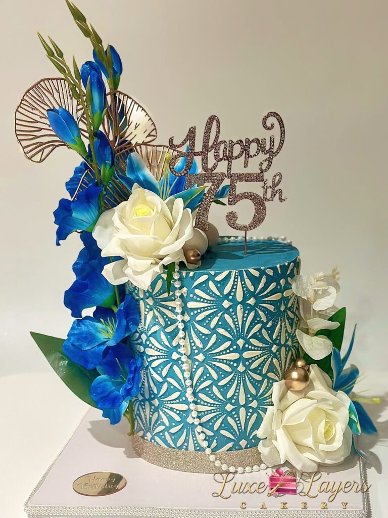Single tier teal and white floral stencil 75th birthday cake with fresh floral accents, gold pearl details, and glitter Happy 75th topper created by Luxe Layers Cakery in Miami Florida.