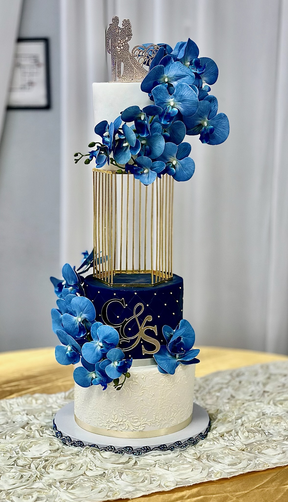 Detail view of three-tier ivory blush fondant wedding cake with handcrafted sugar florals, fan accents, and clean tier banding created by Luxe Layers Cakery in Miami Florida