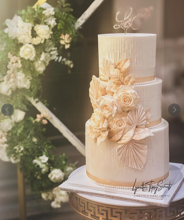 Three-tier ivory and blush fondant wedding cake with vertical textured finish, handcrafted sugar florals, fan details, pearl accents, and monogram topper delivered to Milander Center by Luxe Layers Cakery in Miami Florida