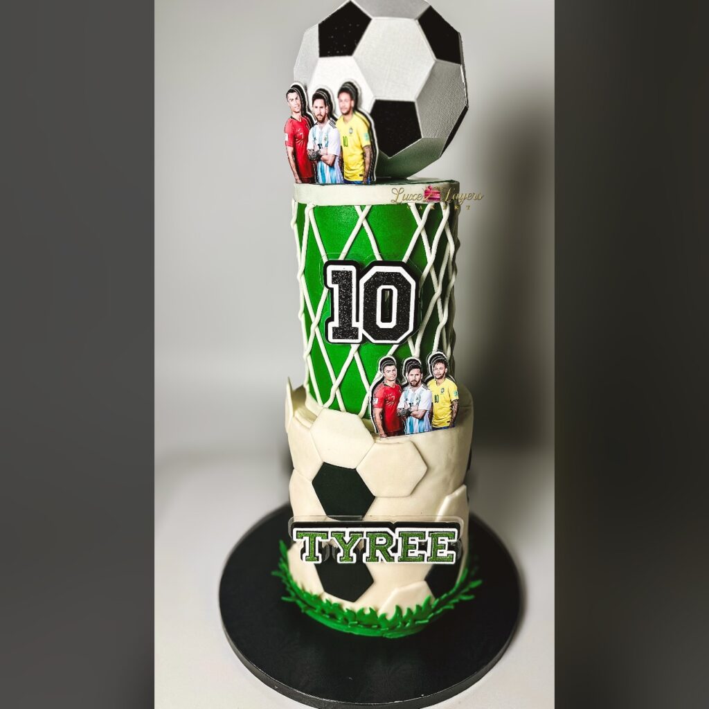 Two tier custom soccer themed 10th birthday cake with sculpted soccer ball topper, fondant soccer textures, player cutouts, and custom name plaque created by Luxe Layers Cakery in Miami Florida.