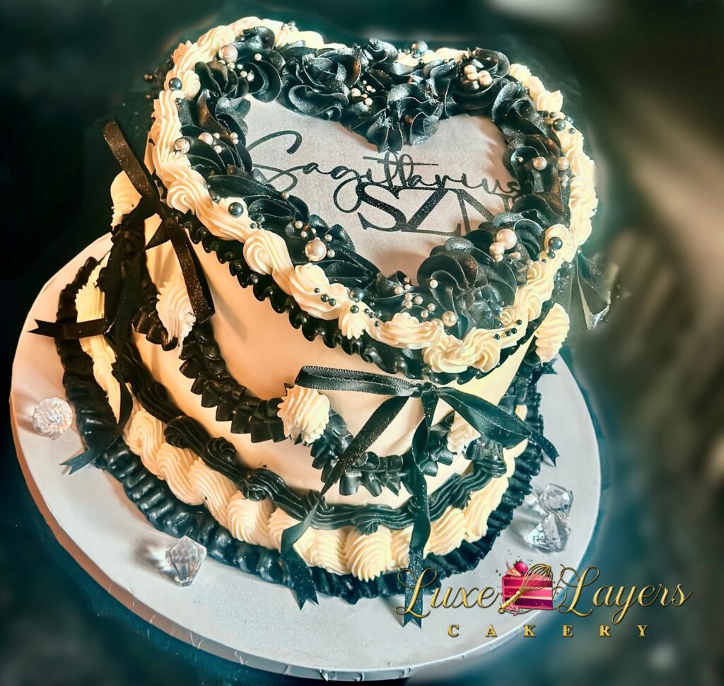 Single tier black and white vintage Lambeth piping burn-away birthday cake with heart shaped top design, decorative bows, edible pearls, and custom burn-away topper created by Luxe Layers Cakery in Miami Florida.