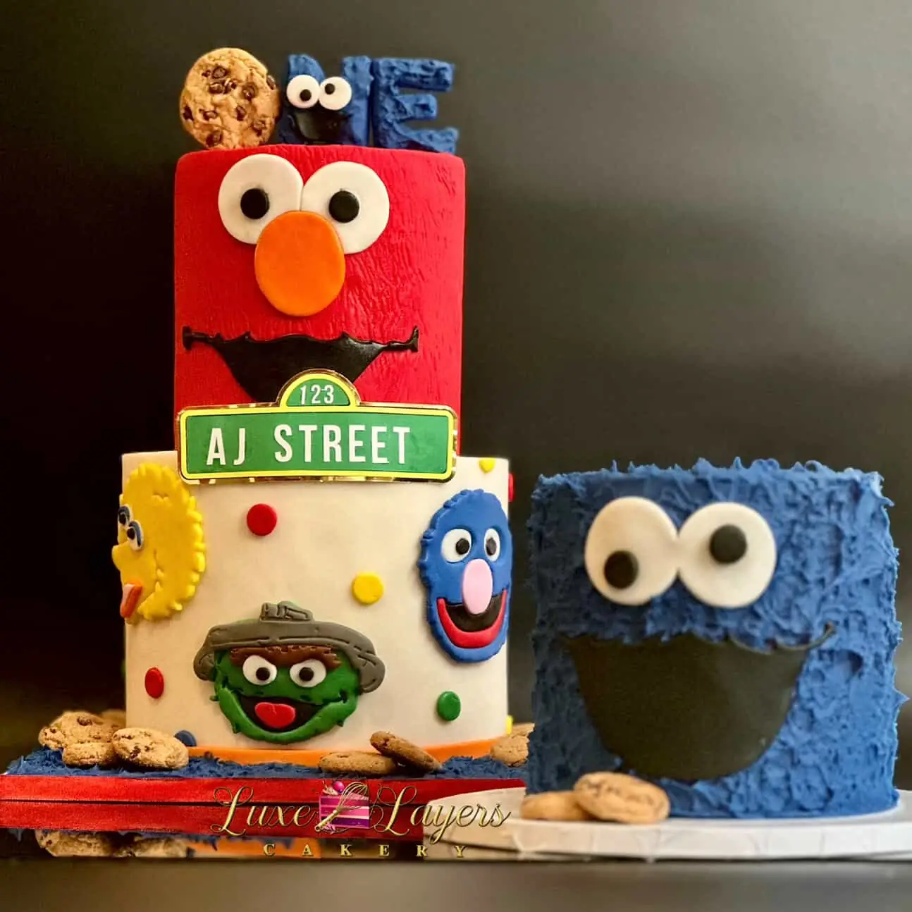 Red, blue, and yellow character-themed first birthday cake detail view with colorful fondant accents — kids birthday cakes Miami by Luxe Layers Cakery