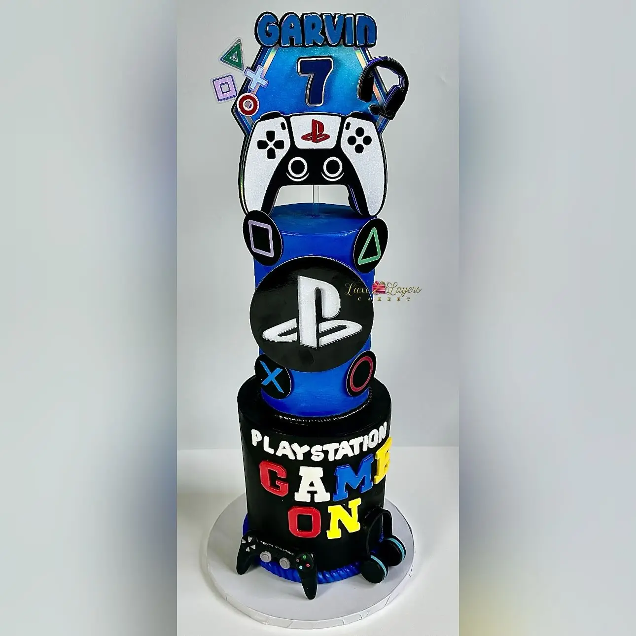 Black and blue PlayStation gaming-themed 7th birthday cake with fondant controller and console details — kids birthday cakes Miami by Luxe Layers Cakery