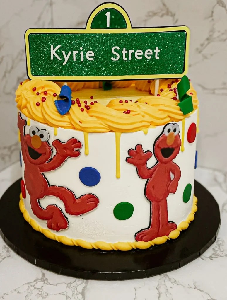 Red and yellow Sesame Street Elmo first birthday cake with fondant character accents and milestone topper — kids birthday cakes Miami by Luxe Layers Cakery