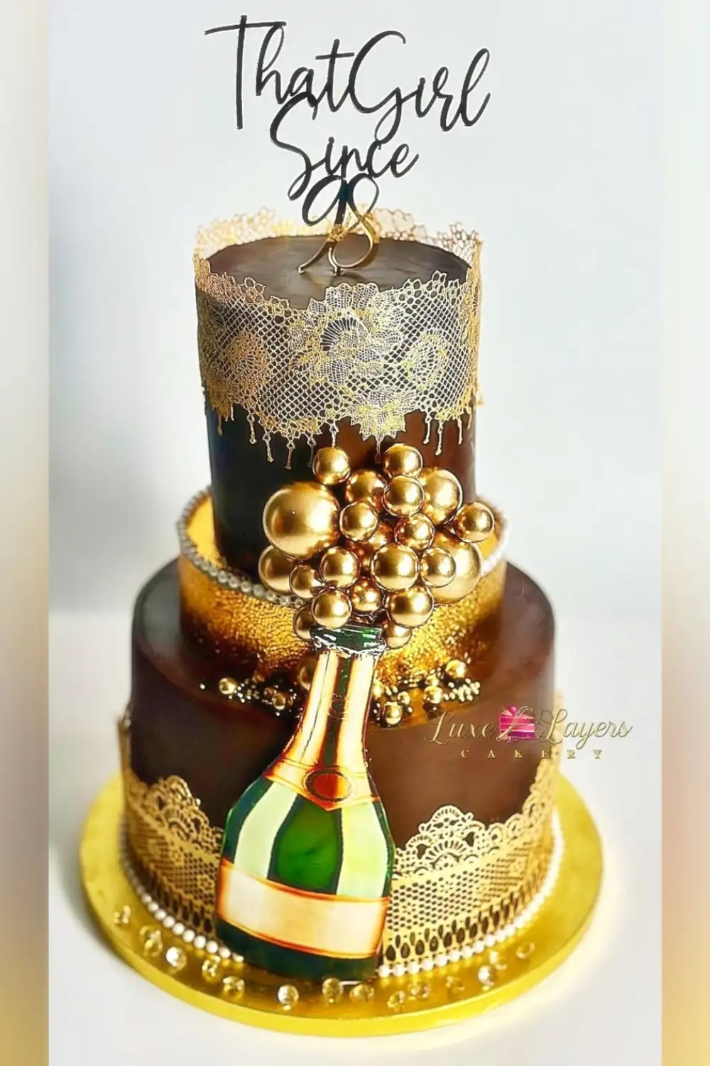 Custom chocolate birthday cake Miami with gold lace detail and champagne decoration by Luxe Layers Cakery