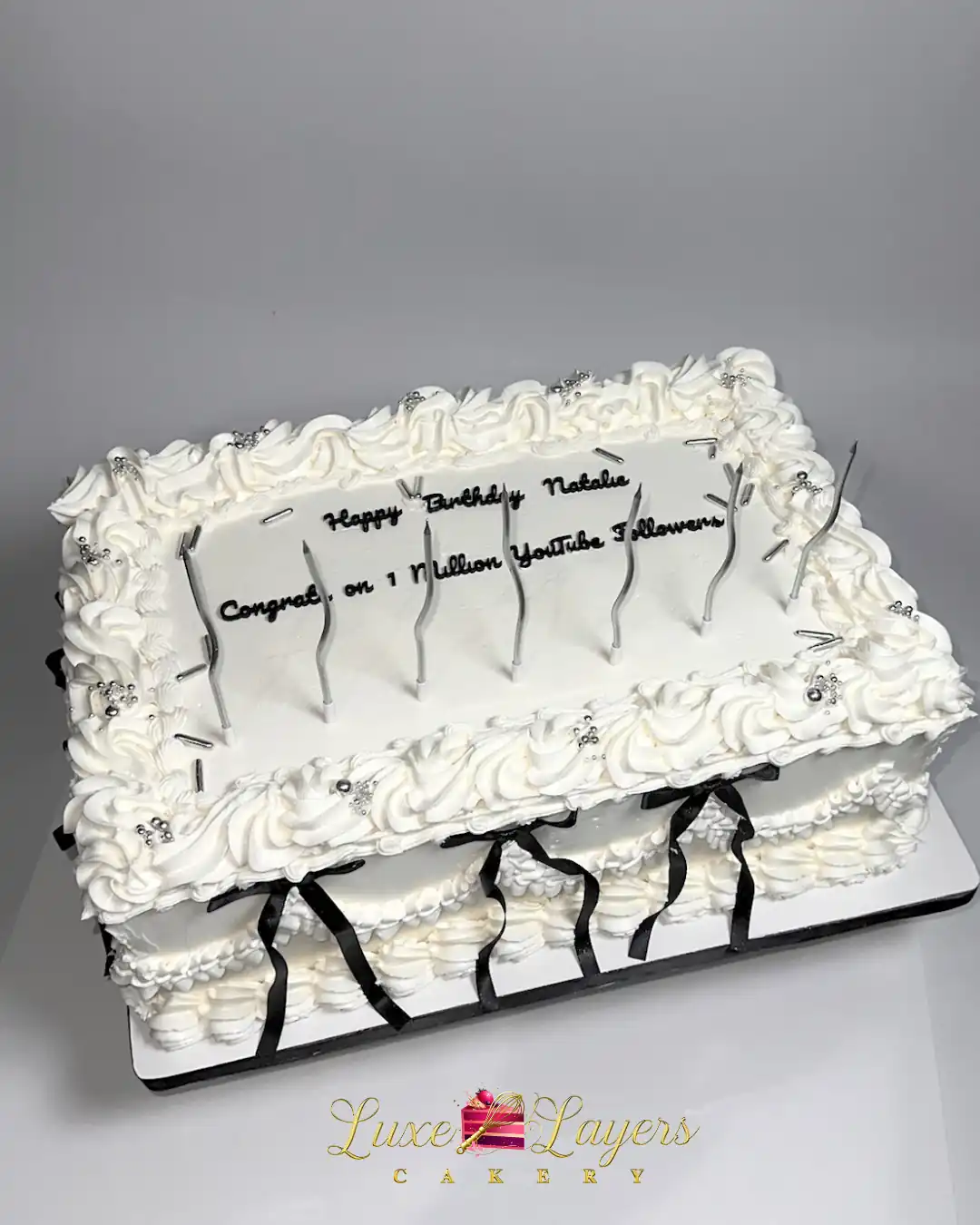 Ivory and black gluten-free sheet cake with buttercream piping, silver dragees, and black ribbon accents, delivered for a milestone celebration near North Miami Beach by Luxe Layers Cakery