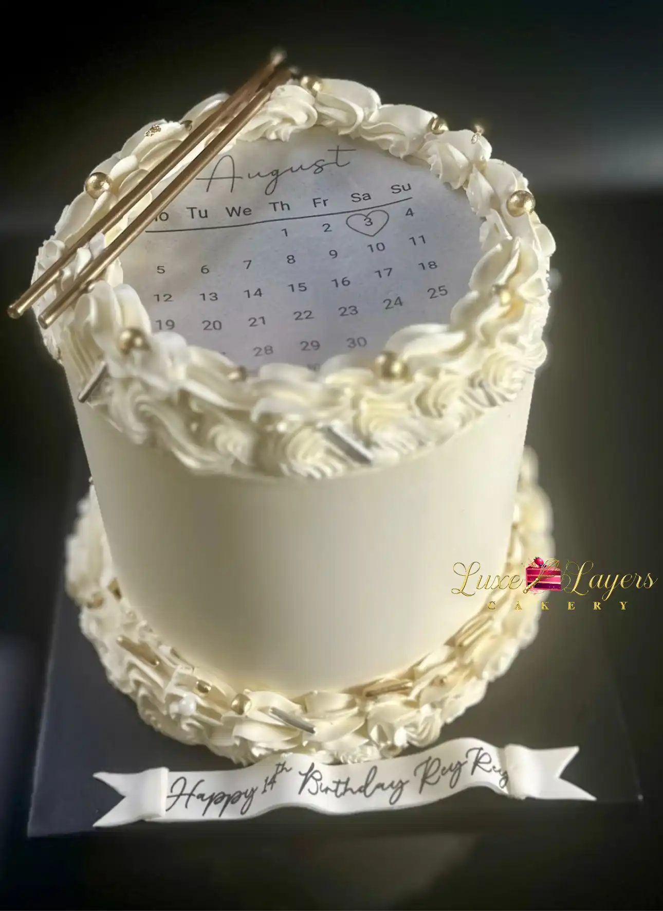 Ivory buttercream birthday cake with gold accents and printed calendar detail, custom cake by Luxe Layers Cakery